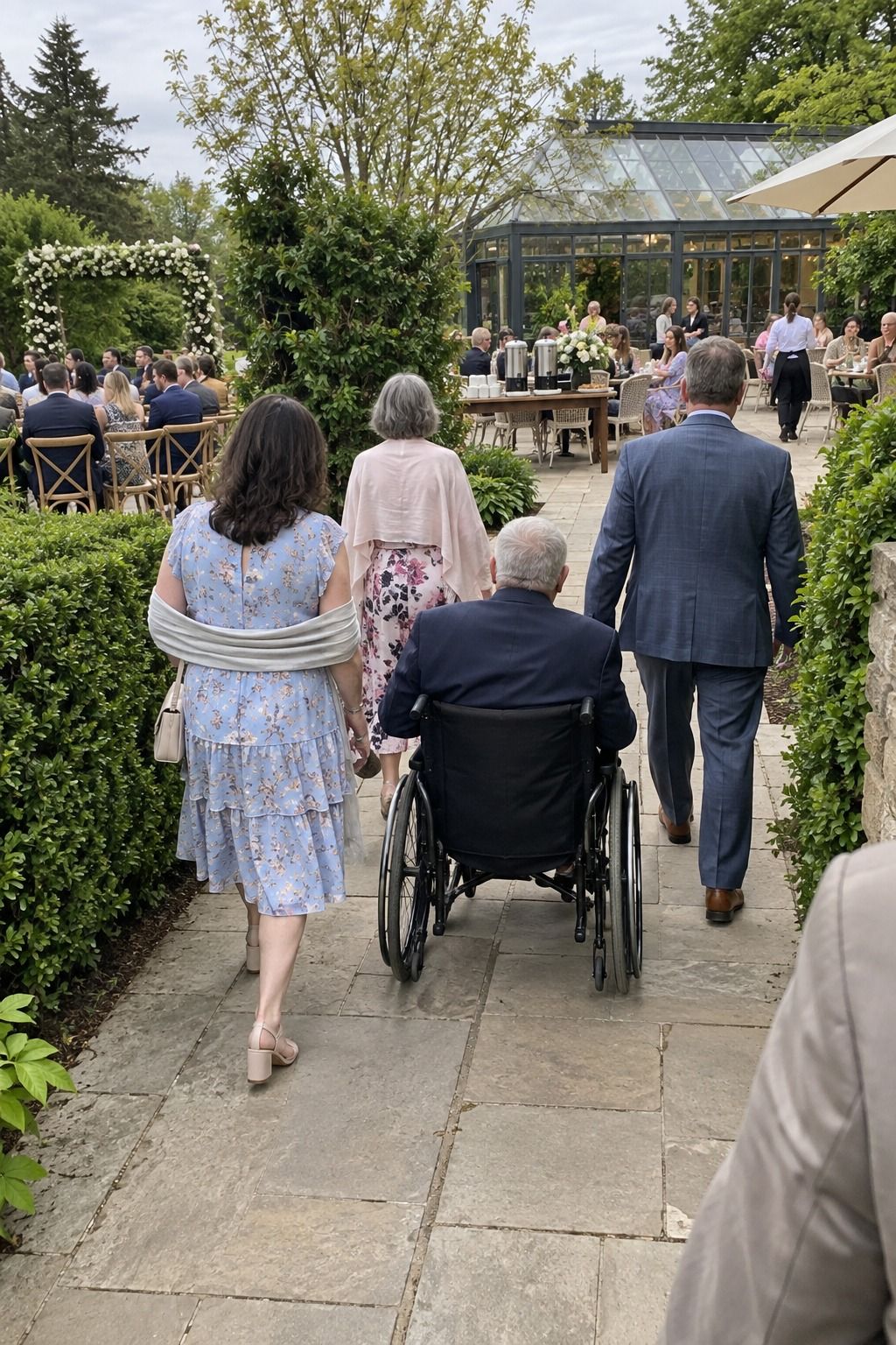Guests, including a wheelchair user, move through a wide hedge opening from ceremony seating to a nearby brunch patio.