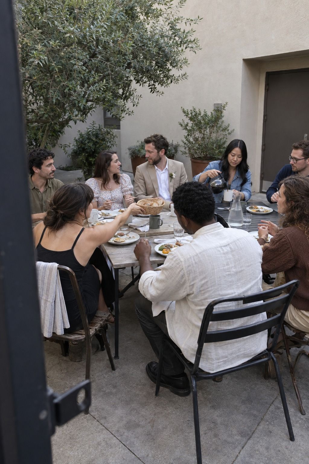 Eight guests share a lived-in community-hall courtyard meal with no full bar, dance floor, escort wall, cake or extra stations.