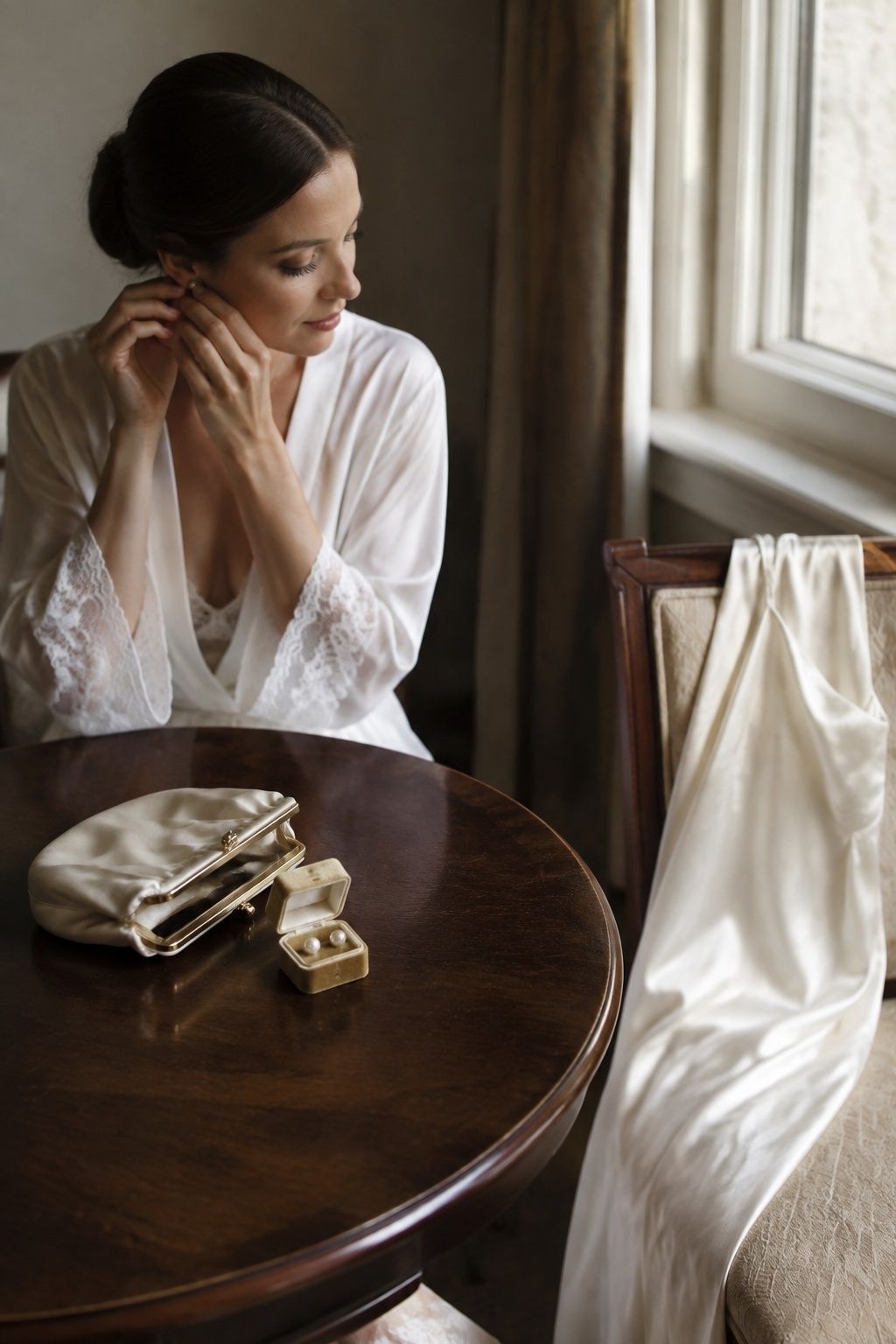 Vintage satin clutch and pearl earrings on a bridal getting-ready table