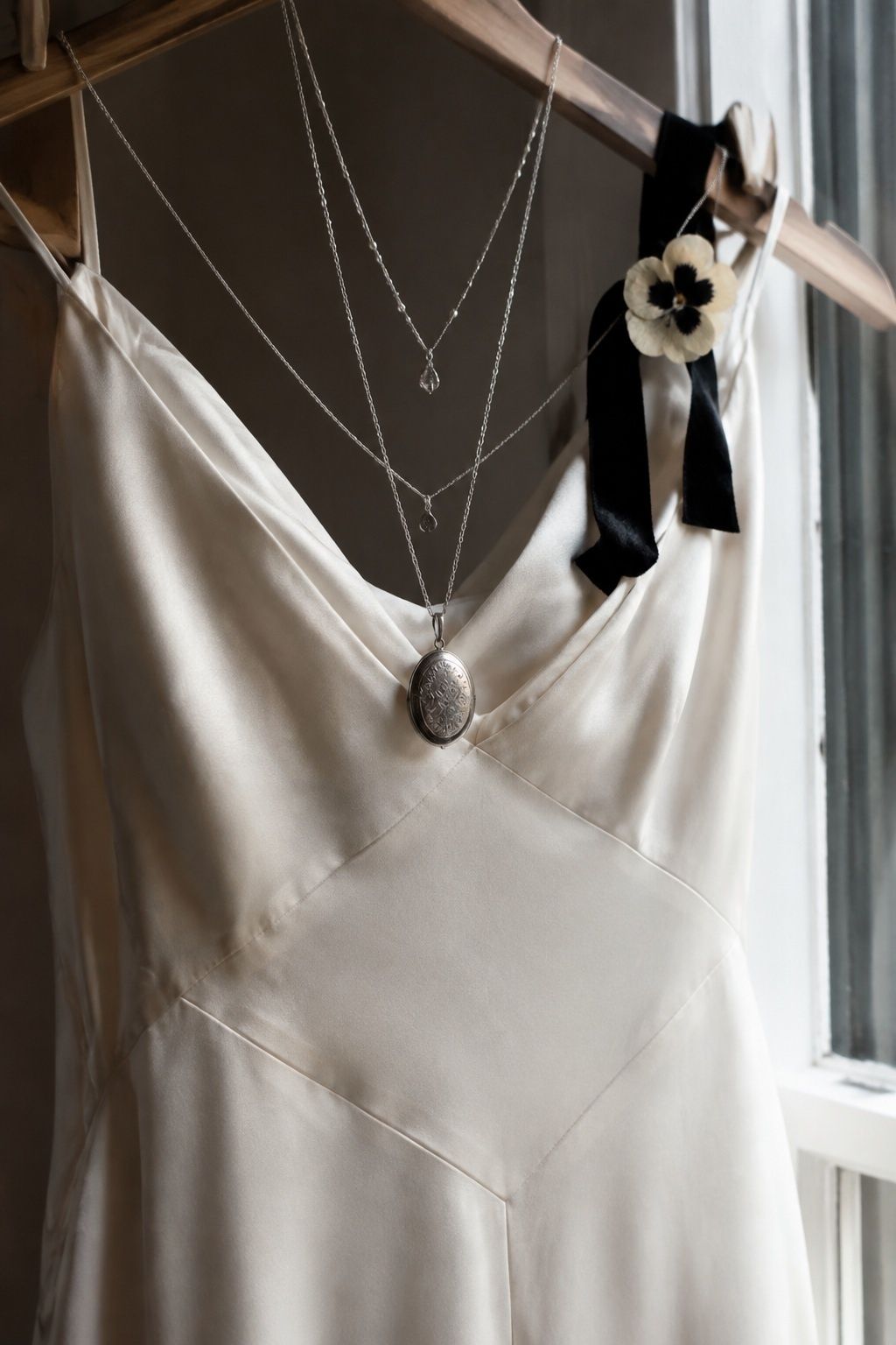 Heirloom pendant anchoring a layered necklace stack