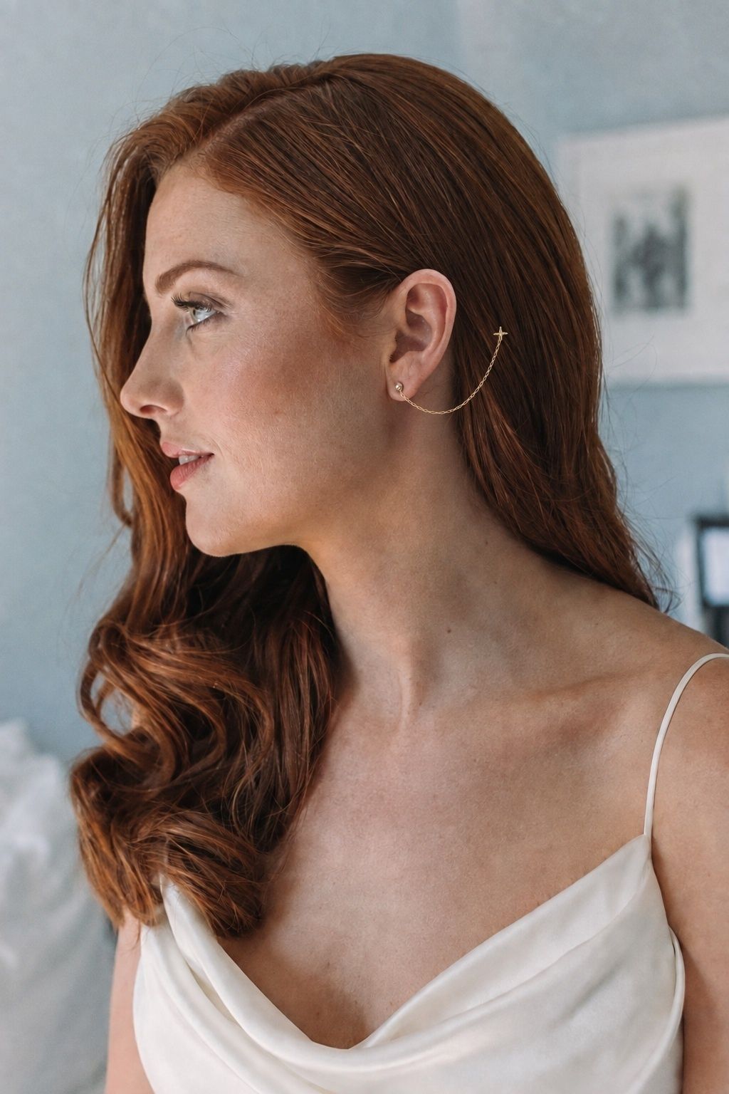Soft side-part hairstyle with a single draped earring chain