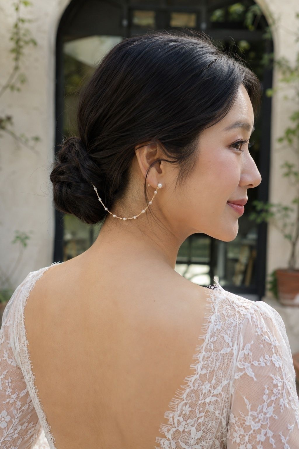 Low bun paired with pearl chain earrings
