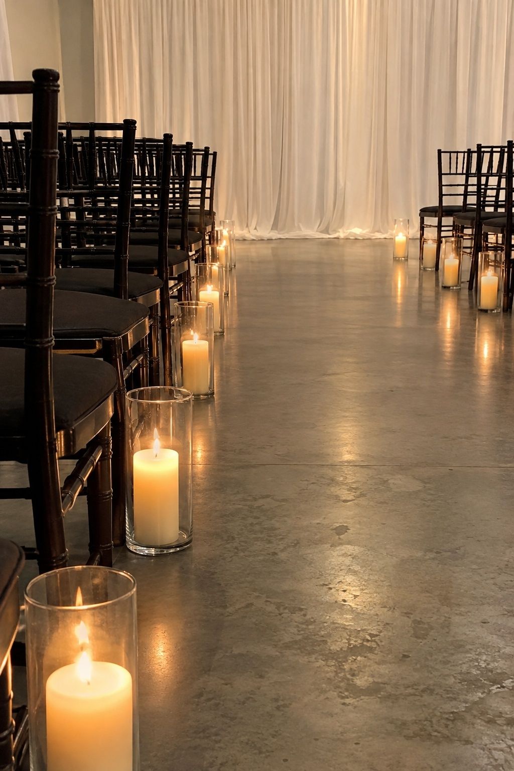 Candlelit aisle lined with hurricane glass