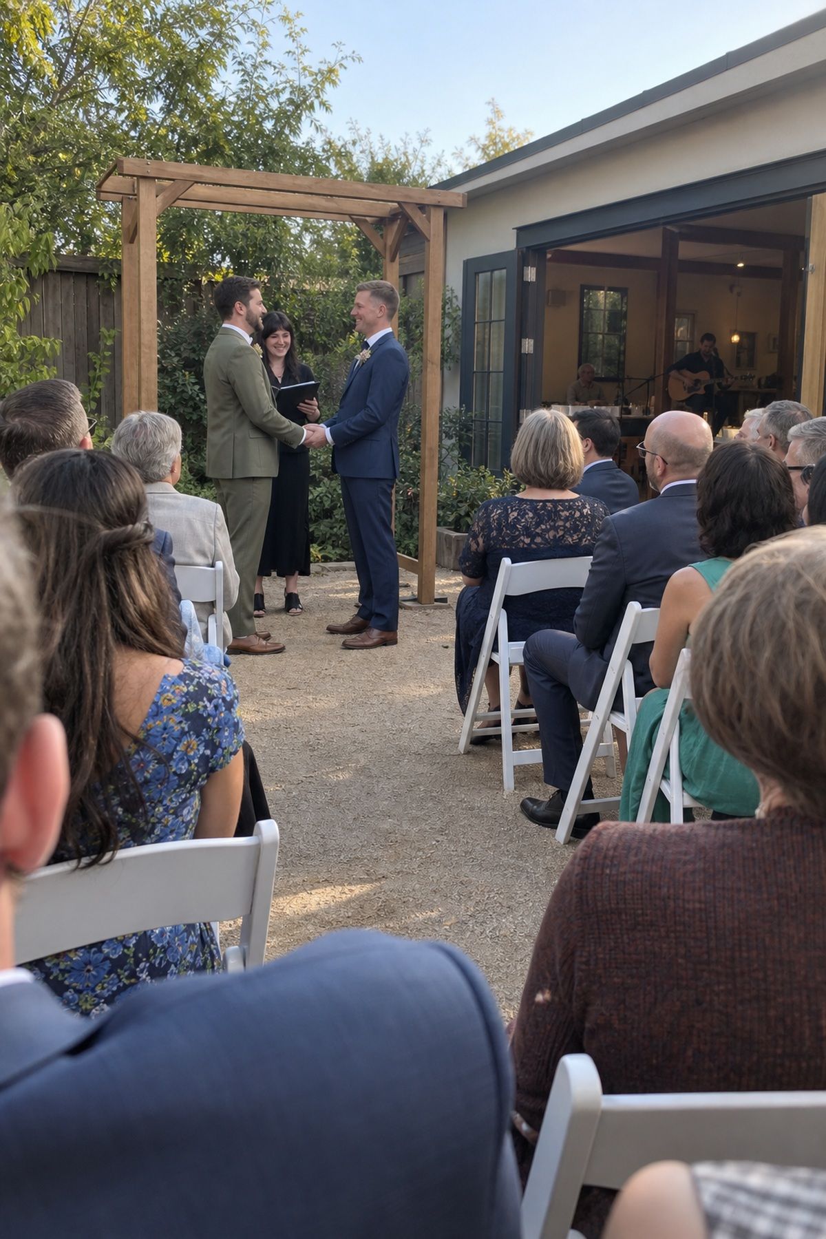 Two grooms exchange vows as guests focus on the intimate wedding ceremony.