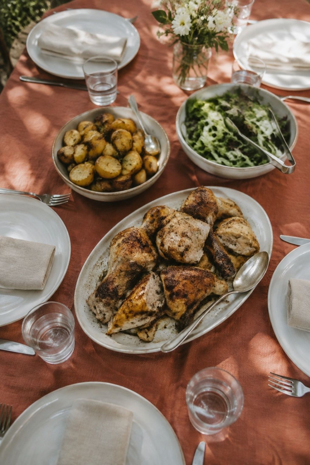 Family-style wedding supper with roast chicken, potatoes and salad