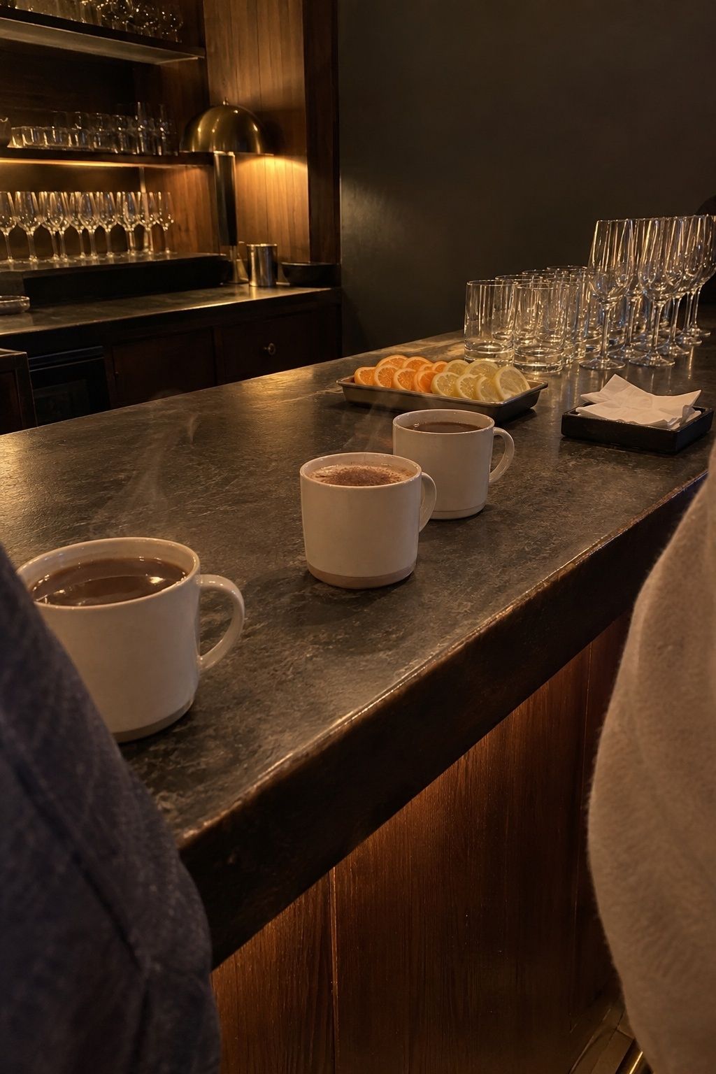 Warm January wedding bar with hot drinks, citrus garnishes, and clean glassware.