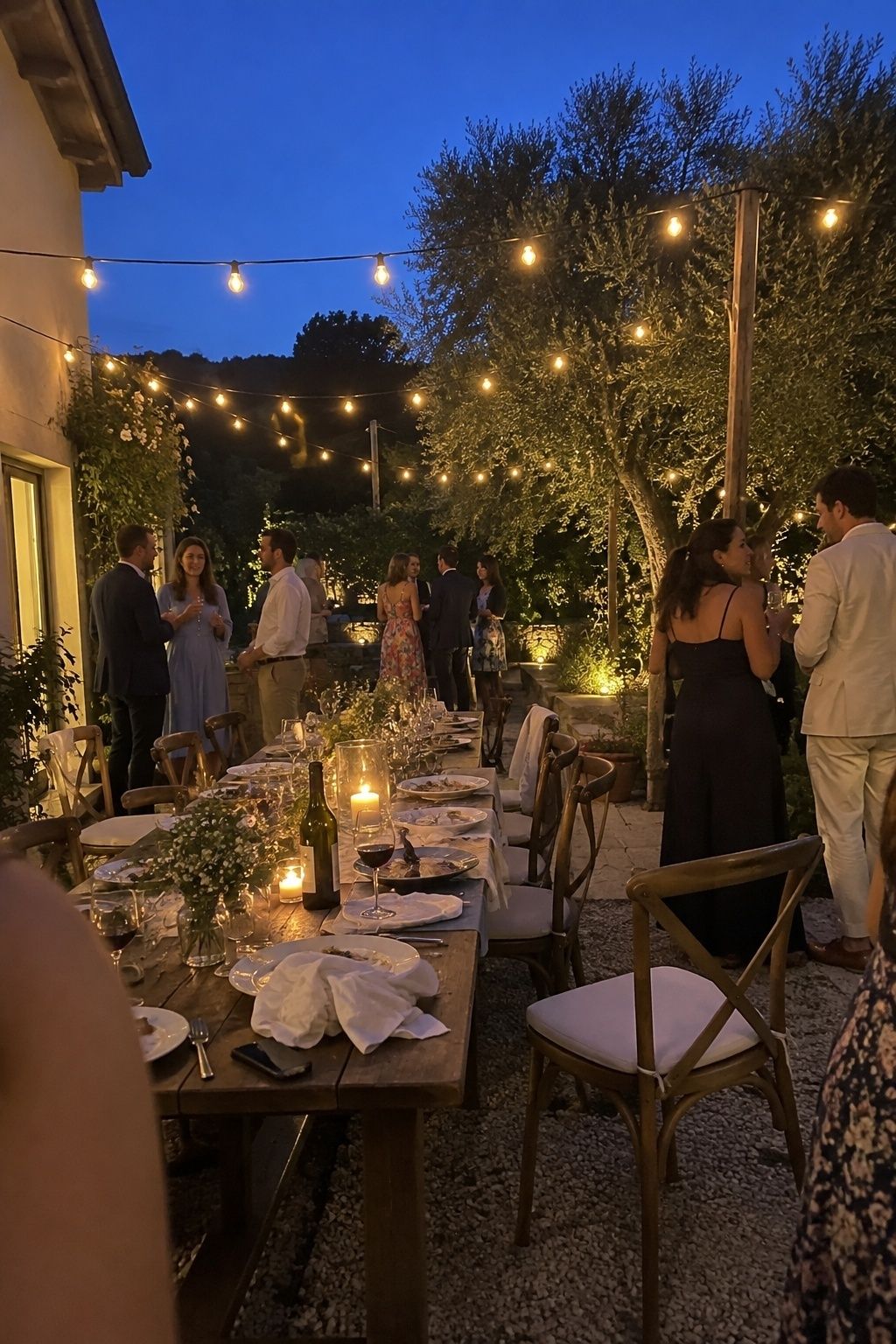 String lights over an intimate July wedding dinner at blue hour