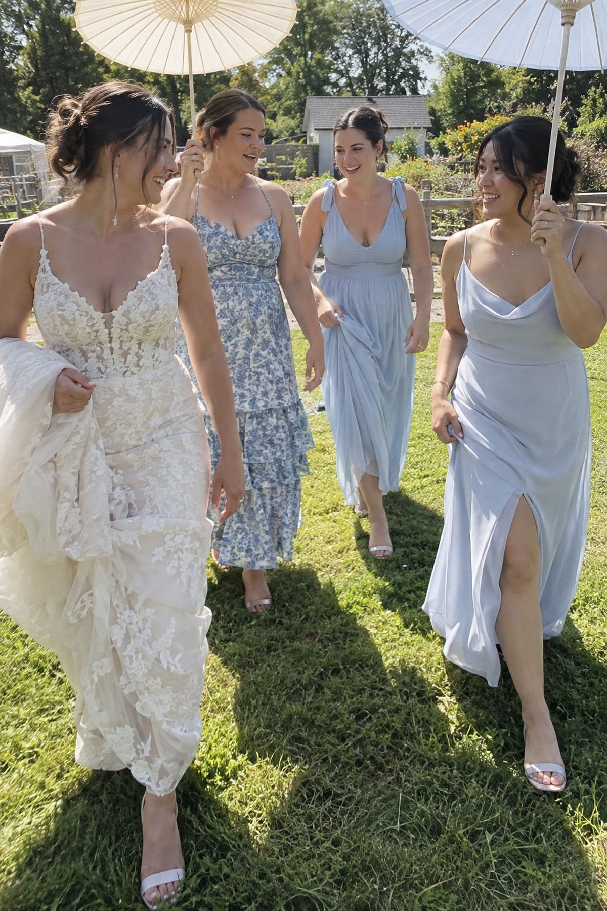 A bride and attendants use coordinated parasols for shade during open-lawn portraits.