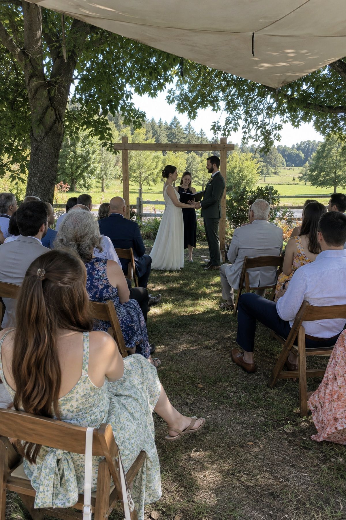 A wide July wedding ceremony view shows guests seated comfortably in deep shade.