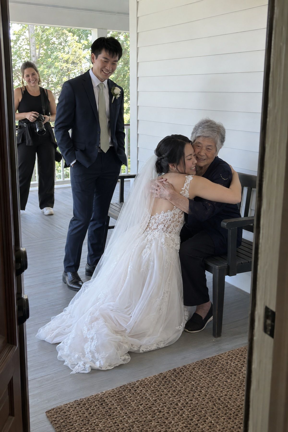 A bride shares an unposed porch hug with her grandmother after family portraits.