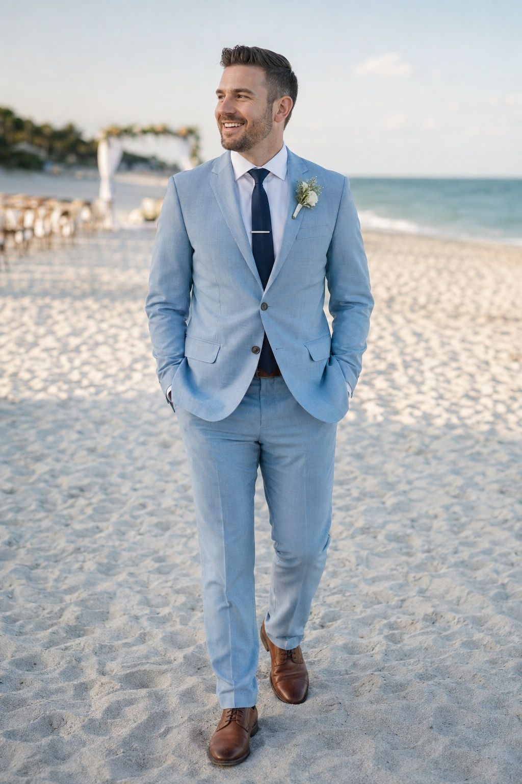 Groom in a pale blue suit during softly lit beach wedding portraits