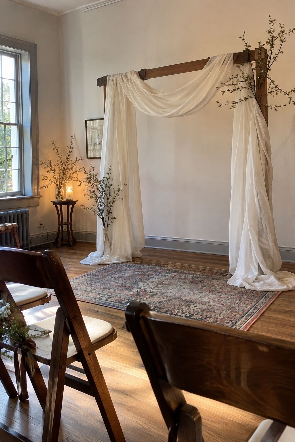 Soft ivory draped ceremony frame with budding March branches
