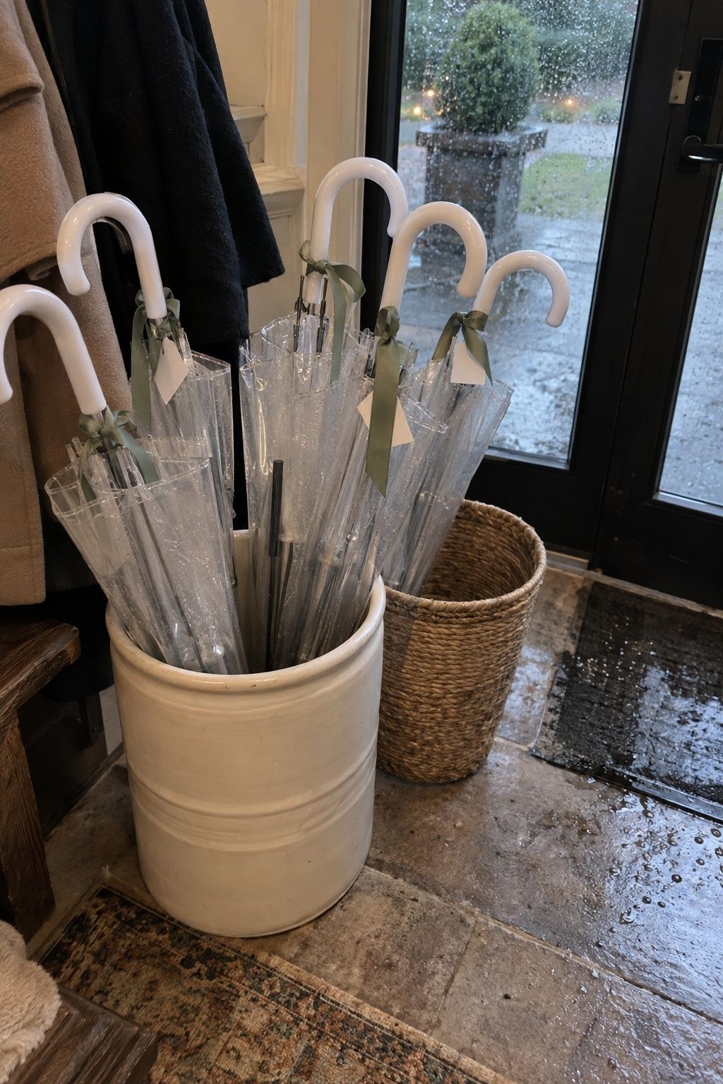 Clear umbrellas displayed at a rainy March wedding entrance