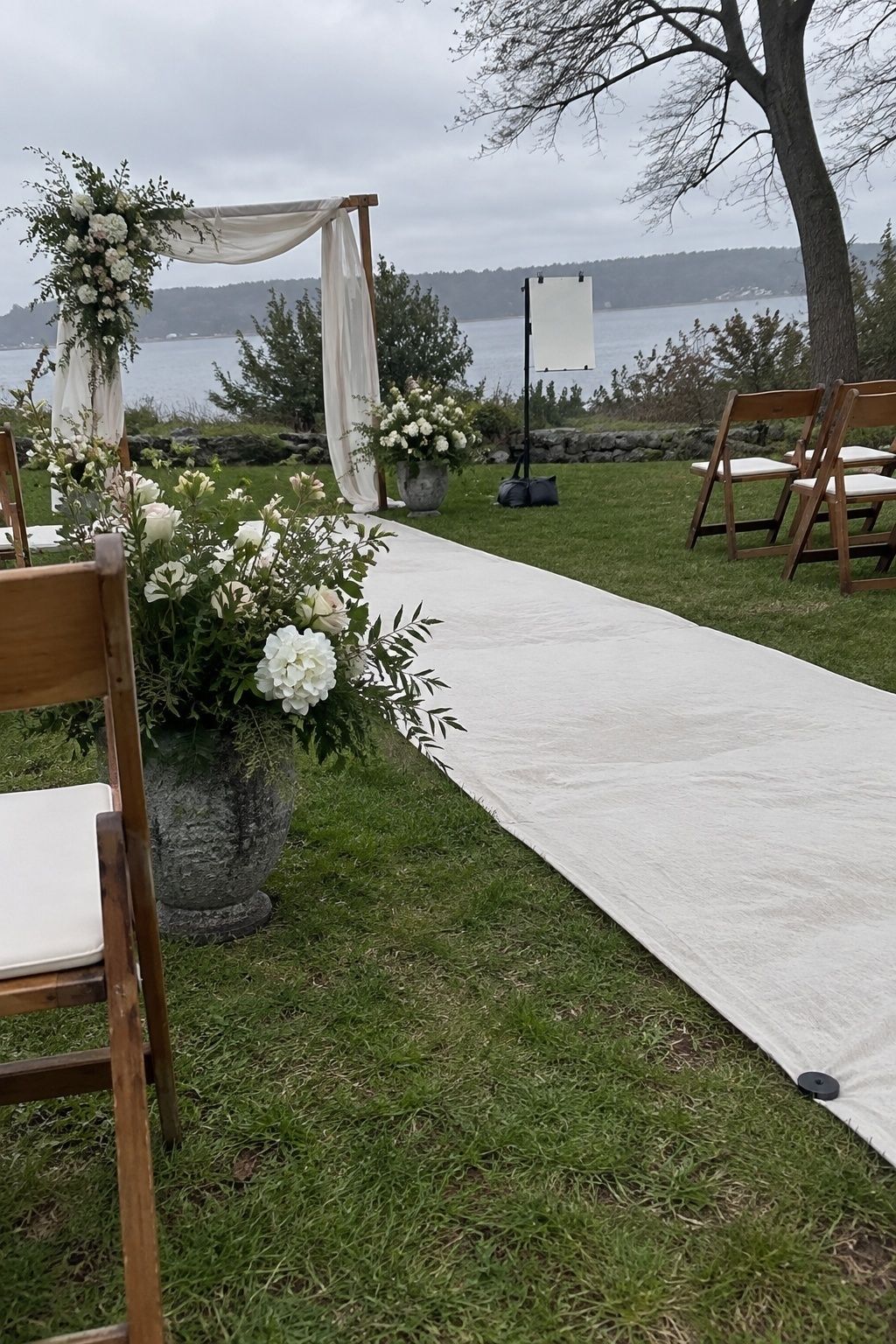 Wind-smart outdoor March wedding decor with weighted sign and low flowers