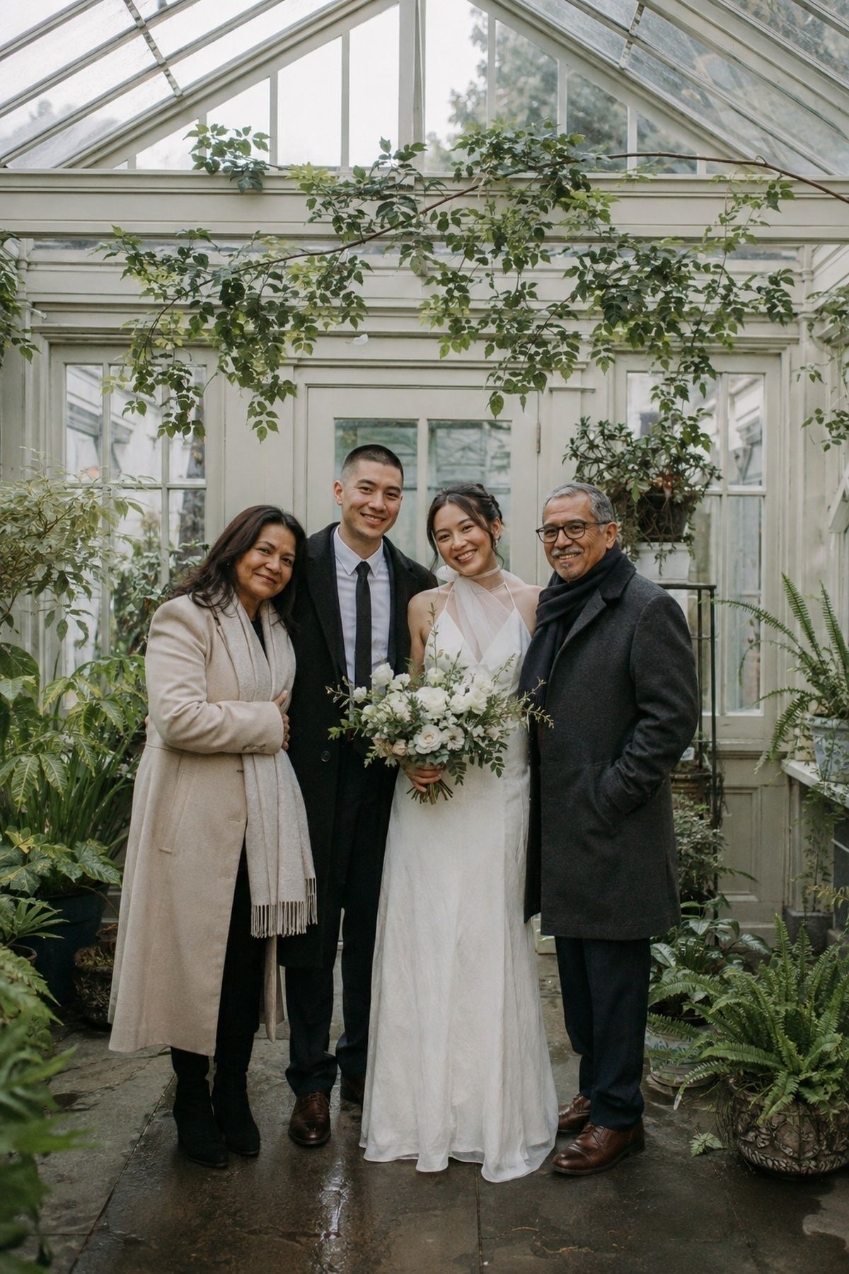 March wedding couple and close family inside a conservatory with filtered spring light