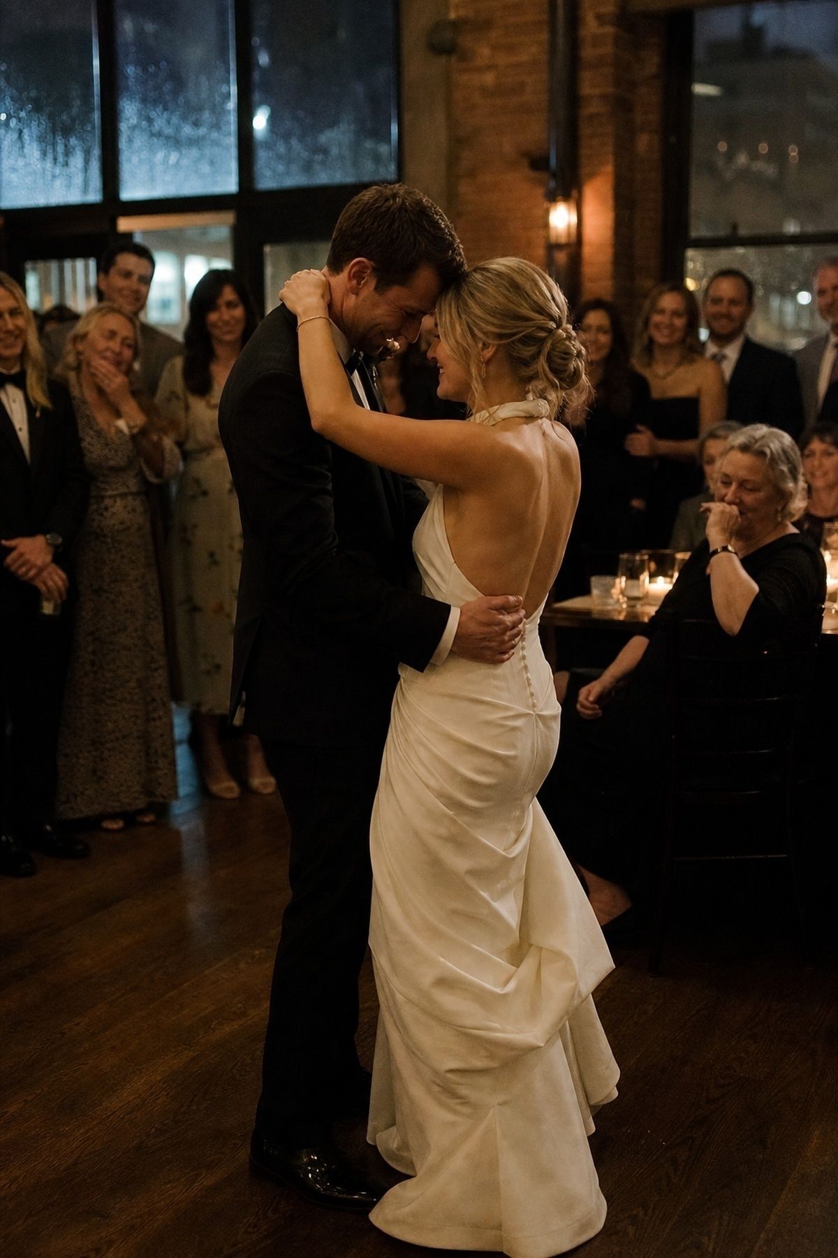 Warm indoor March wedding first dance with family and friends gathered close