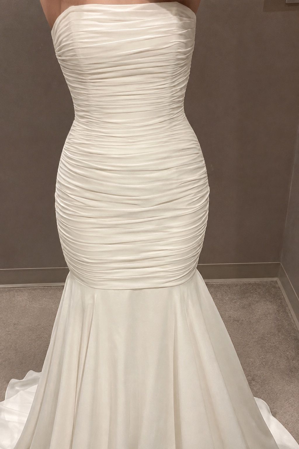 Close view of subtle ruched bodice continuing smoothly into the hip.