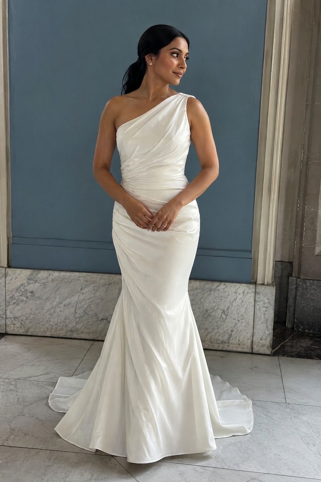 One-shoulder neckline directing diagonal bodice draping in a city hall.