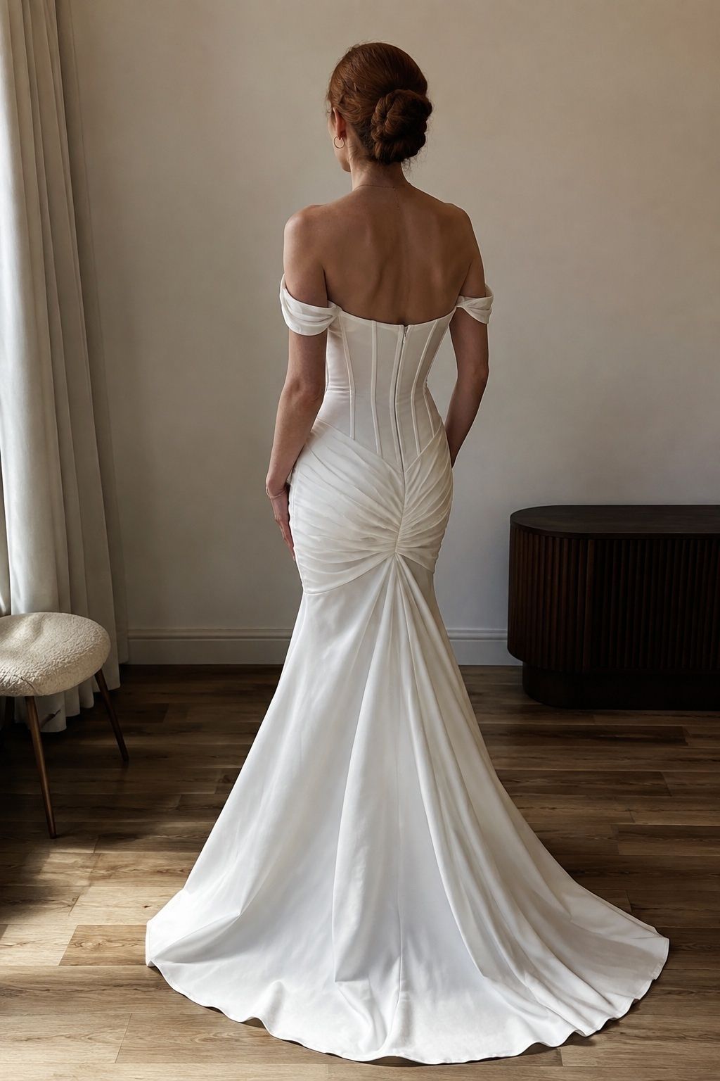 Draped corset construction with a low flare and short train from rear three-quarter view.