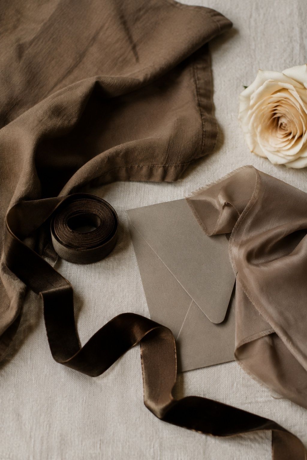 Mocha linen, chocolate velvet ribbon, taupe paper and cappuccino silk layered on cream fabric.