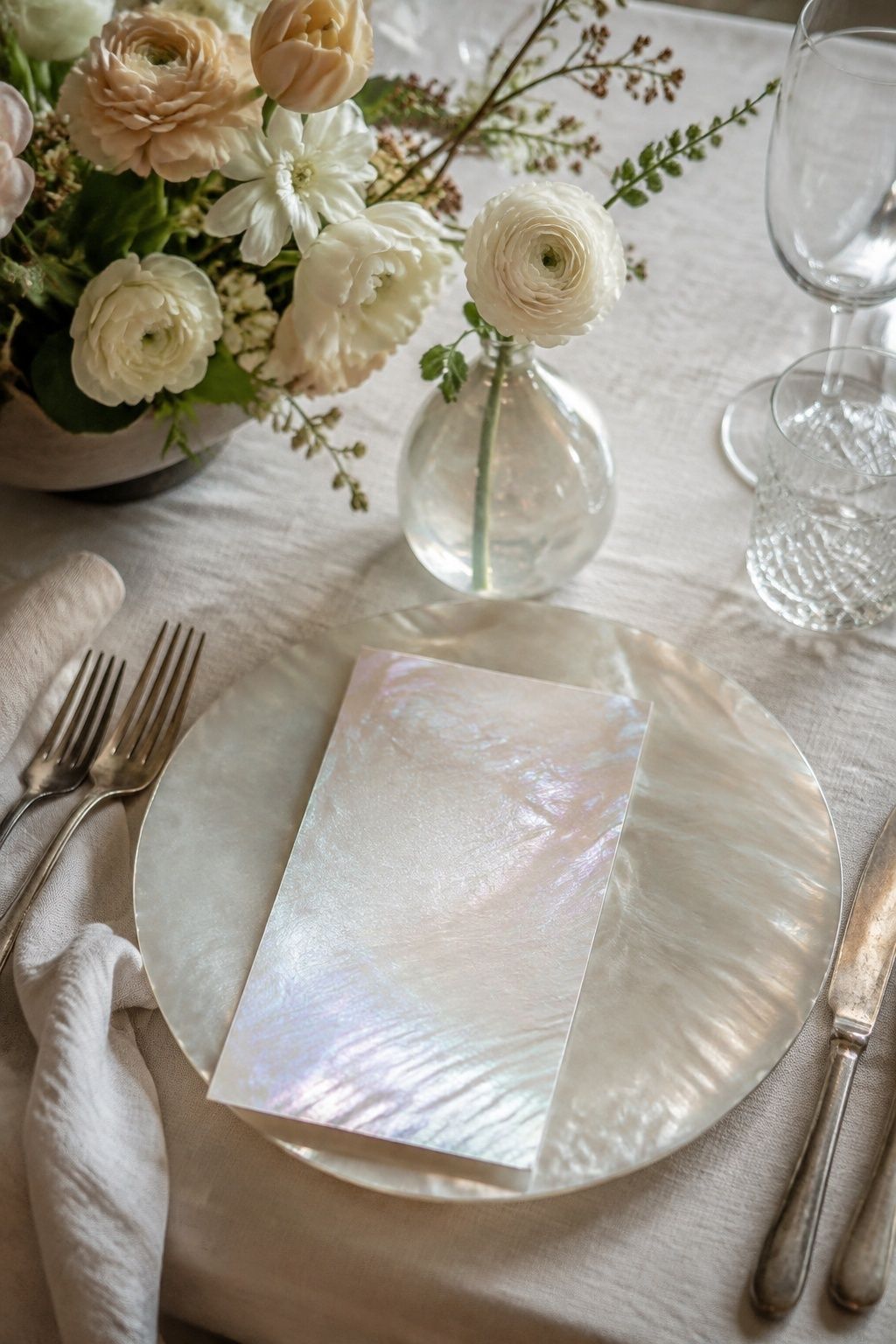 Opalescent details add restrained luminosity to an ivory wedding place setting.