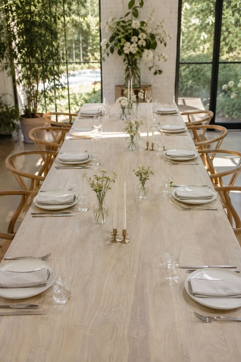 A long modern wedding table uses open space between bud vases and candles.