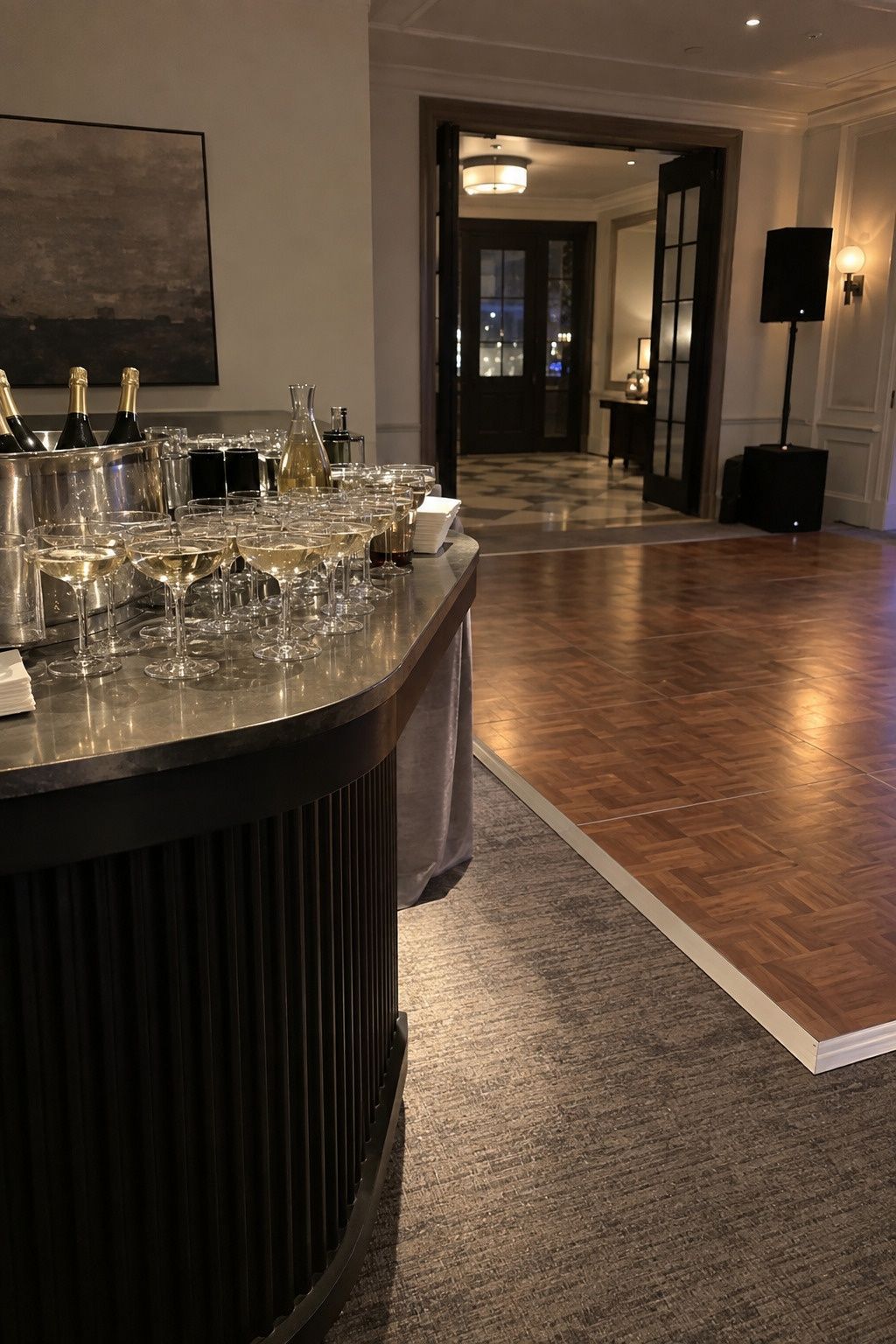 A compact bar sits next to the room's energy while the entrance and circulation stay open
