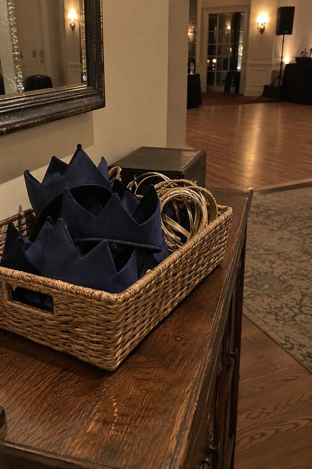 A small basket of midnight-blue fabric crowns and gold headbands keeps party props cohesive