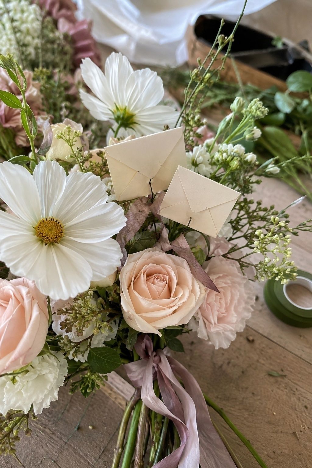 Tiny envelopes tucked between bouquet flowers