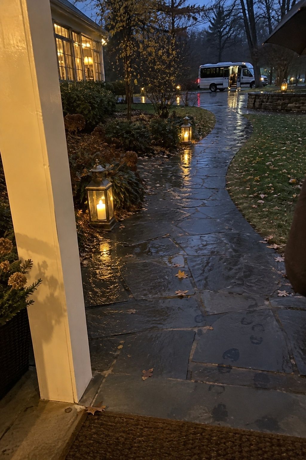 Lanterns lighting a wet arrival path to a November wedding shuttle.