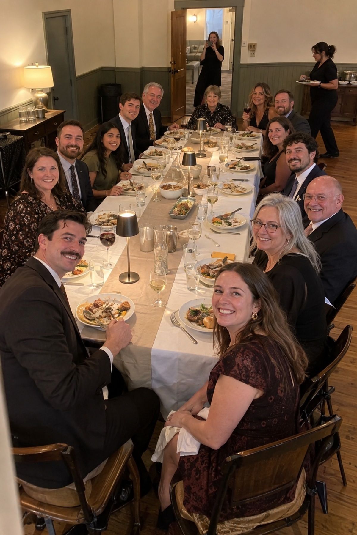 Every guest gathers around one long table for a complete November wedding dinner portrait.
