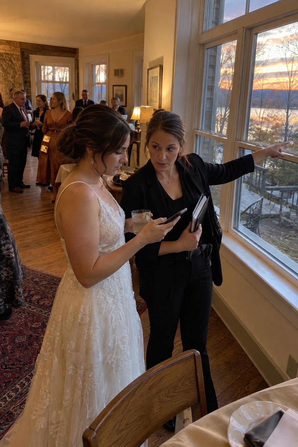 A coordinator and newlywed check the fading October light before cocktail hour.