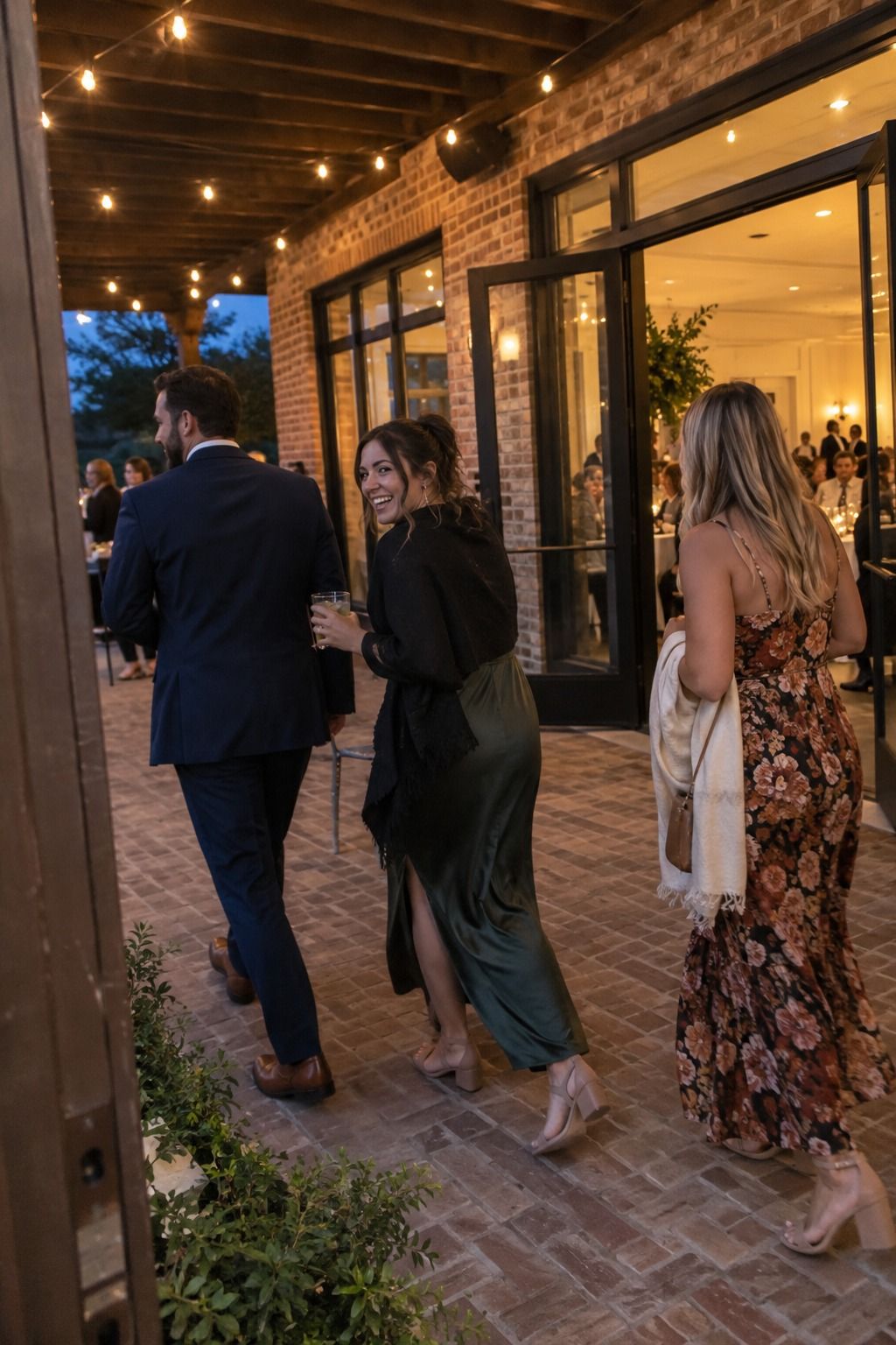 Guests move between dinner and dancing across a pre-lit October patio.