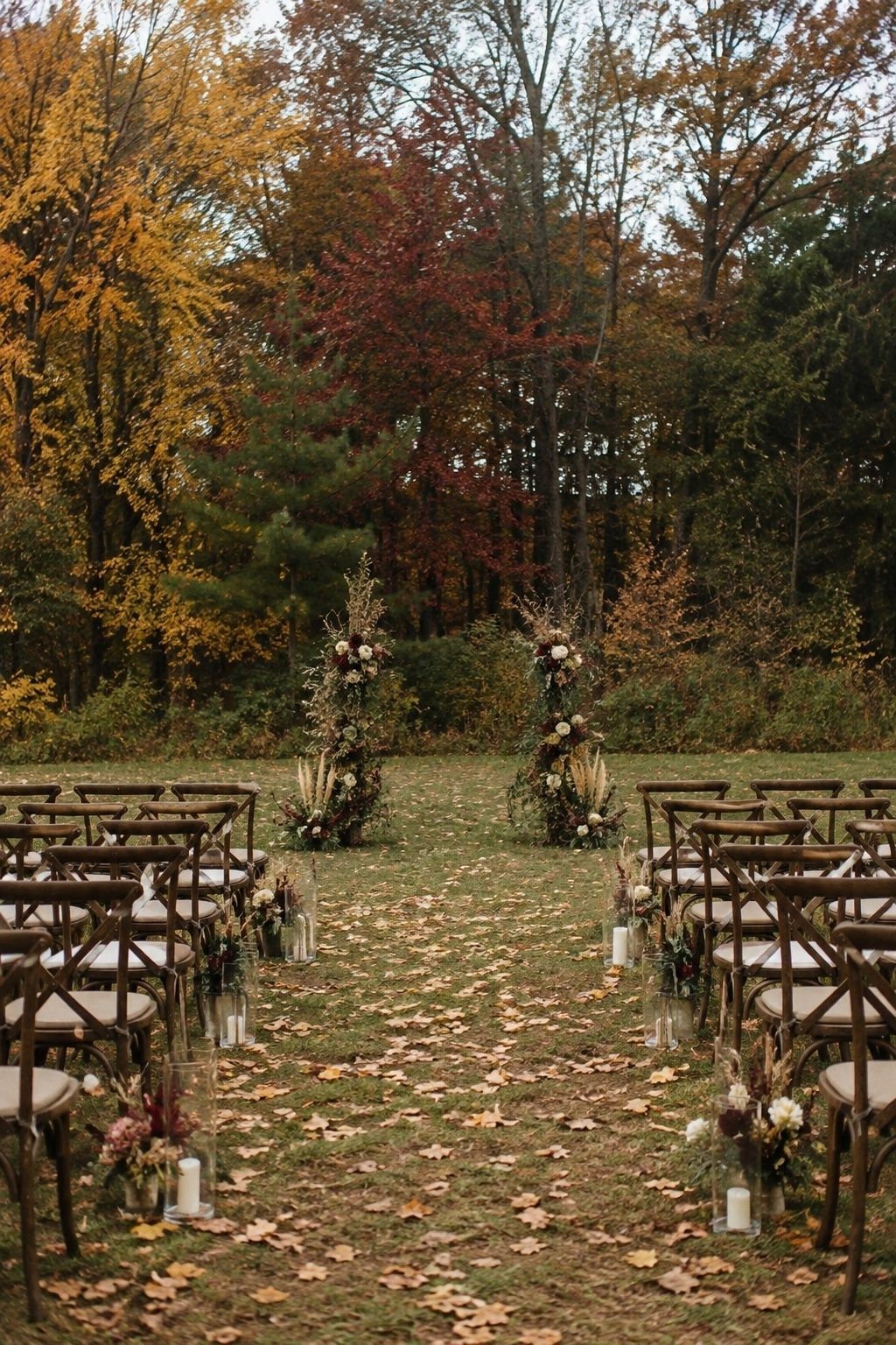 Outdoor fall ceremony with a layered tree line as the backdrop