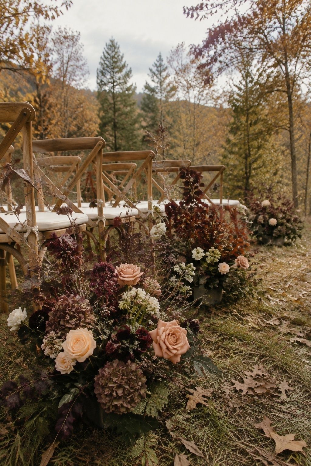 Low wind-safe autumn florals along an outdoor ceremony aisle