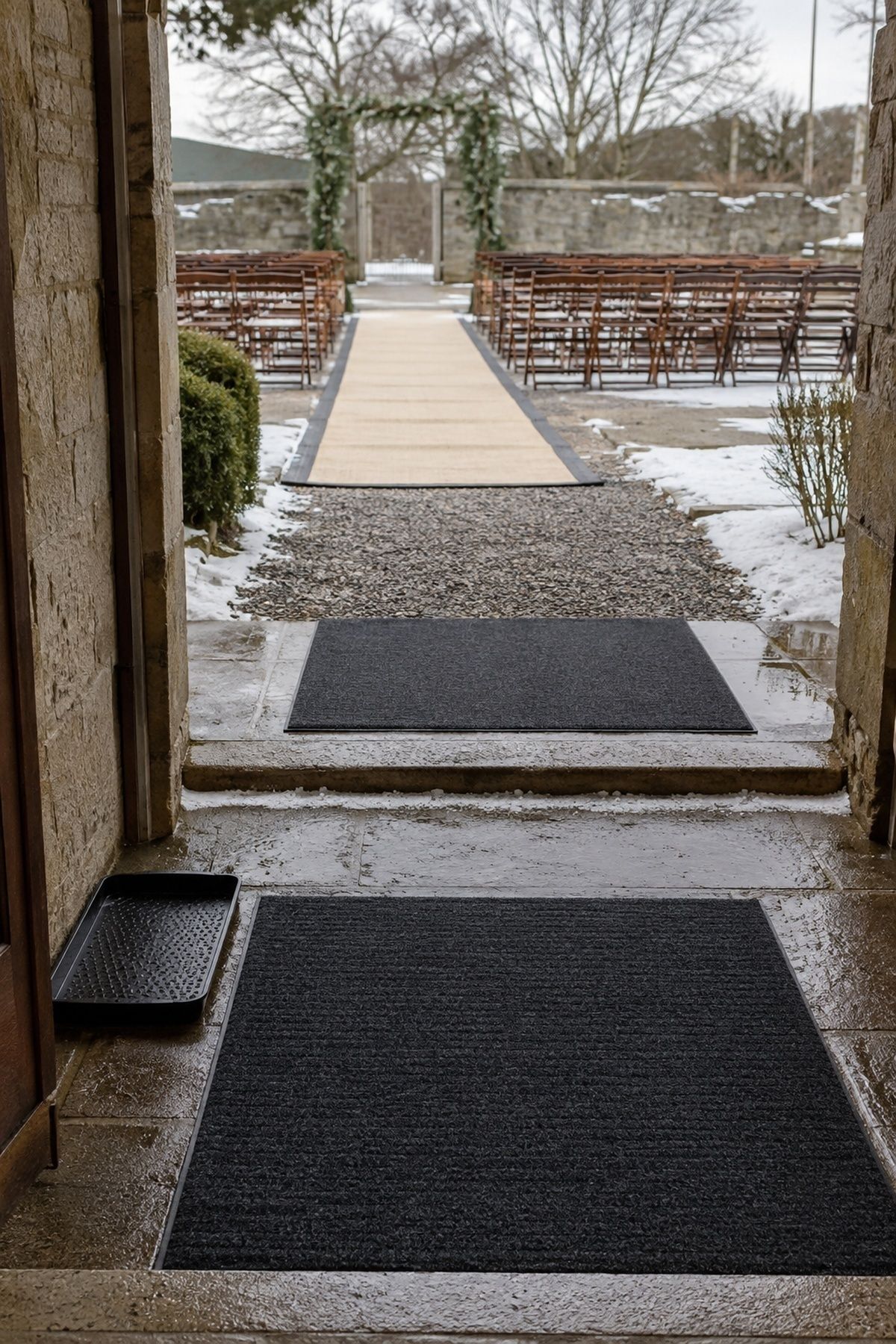 Flat non-slip mats and secured runner on a winter wedding ceremony route
