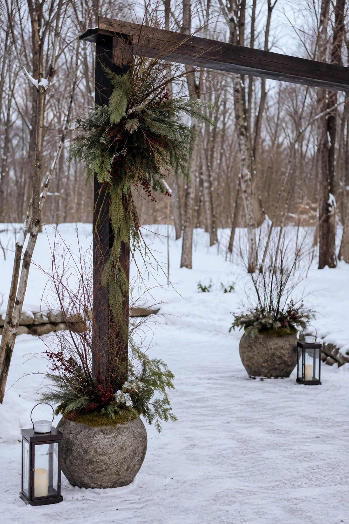 Wind-stable winter ceremony arch with secured greenery and heavy stone vessels
