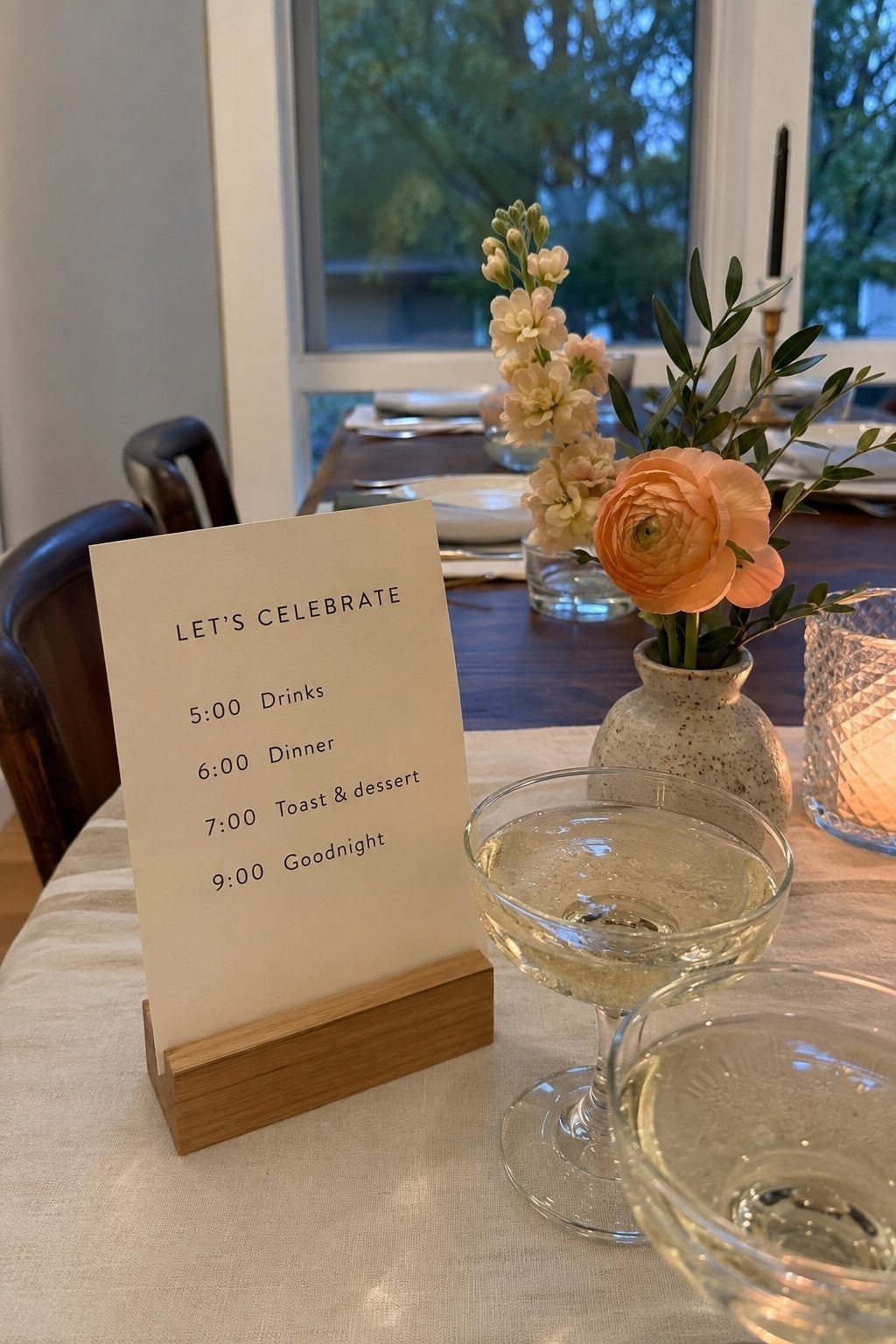 Simple celebration schedule beside sparkling drinks and flowers