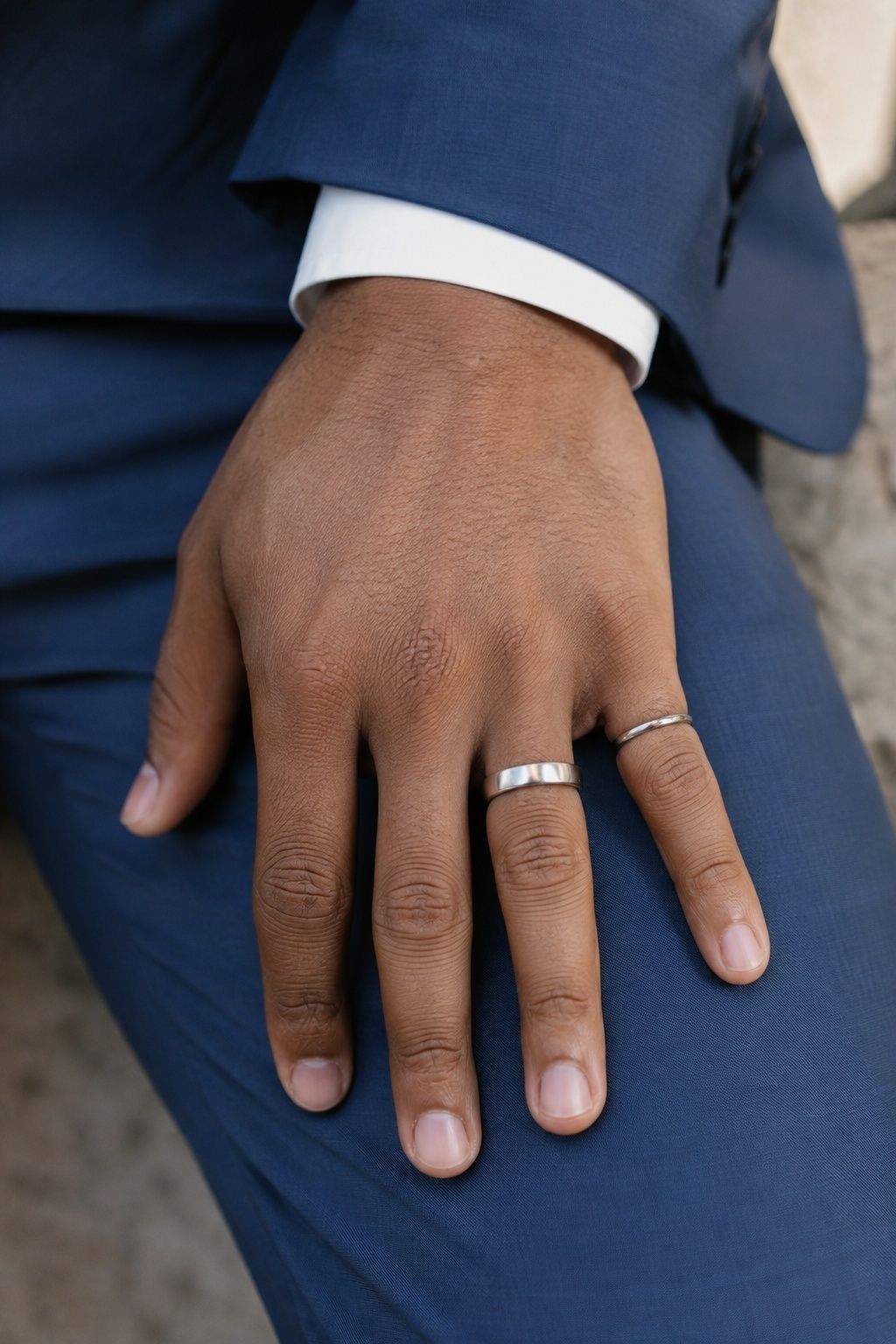 Slim pinky band beside a simple wedding ring