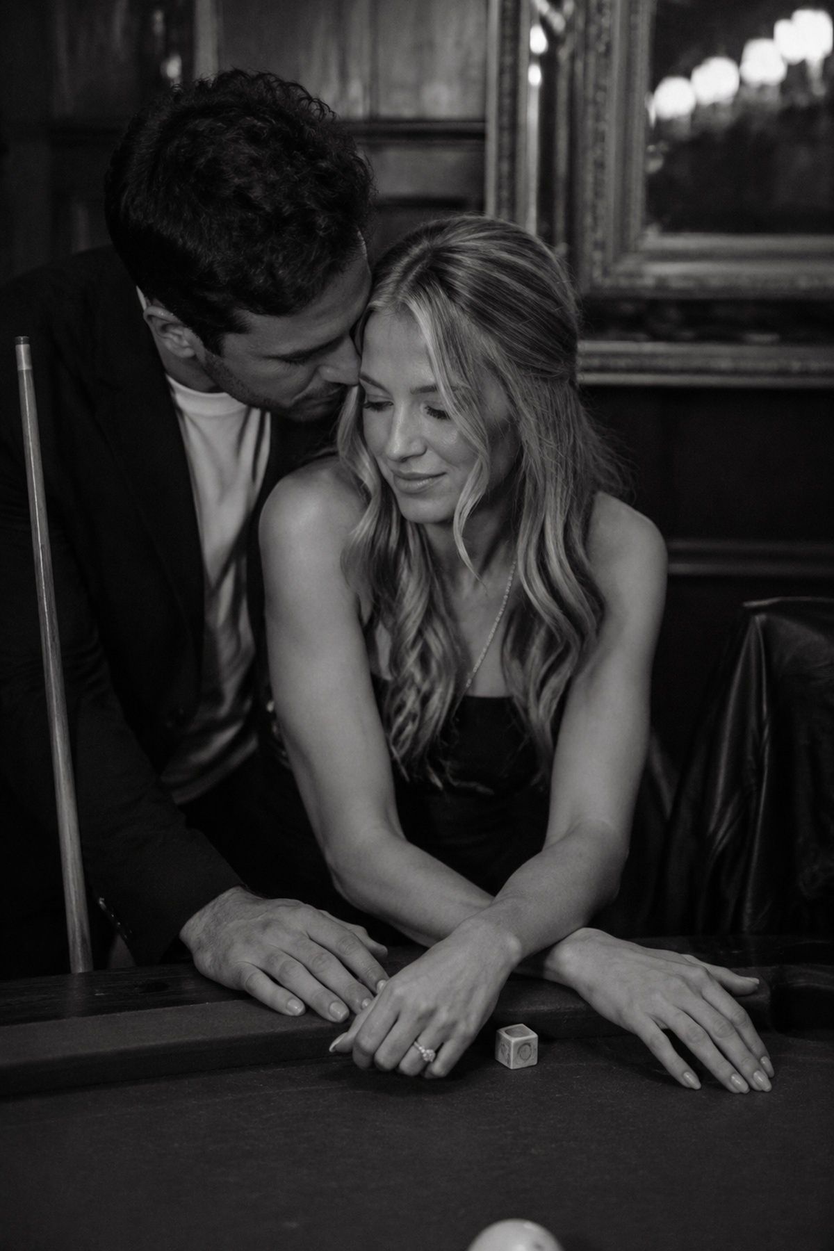 Black and white pool hall engagement close portrait with hands and cue detail