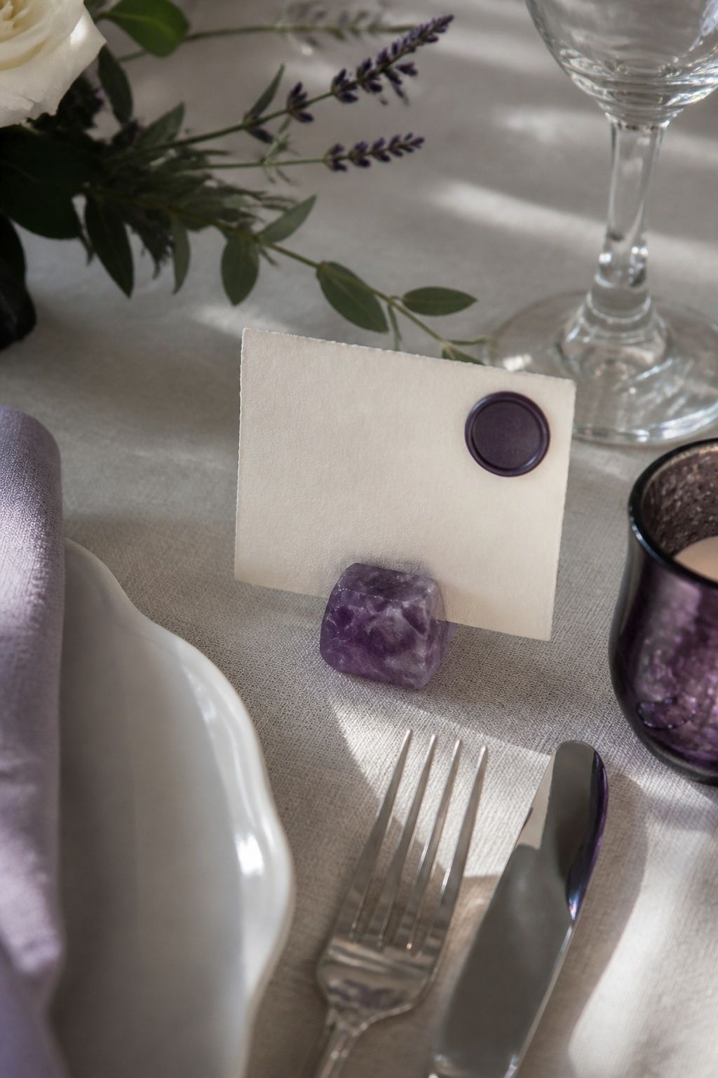 Small amethyst place-card accent on a pearl and lavender wedding table