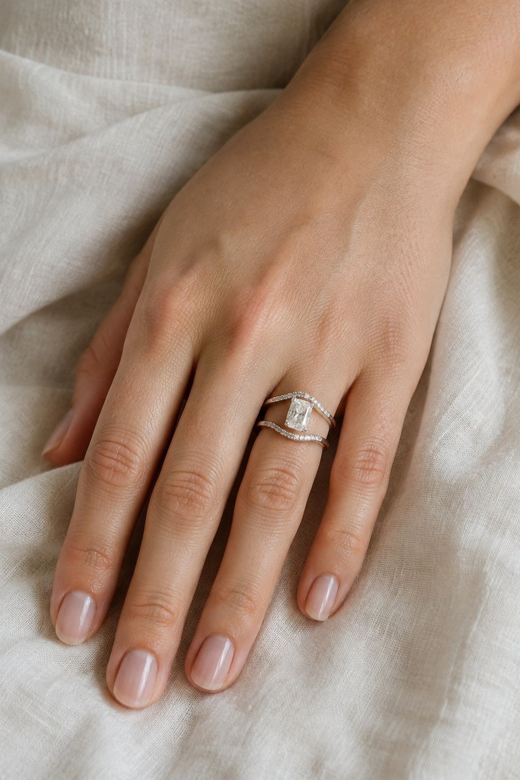 Enhancer band wrapped around a radiant engagement ring