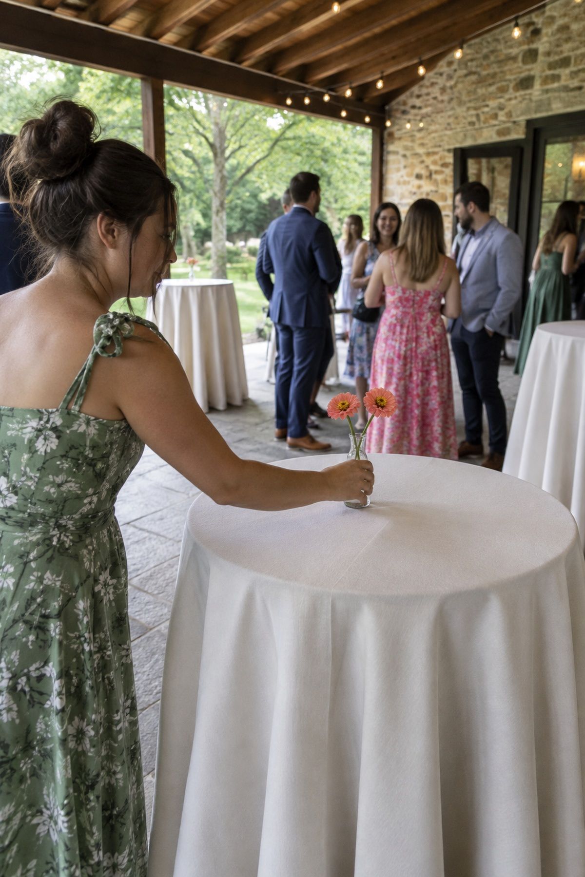 A friend places a small coral bud vase on an empty cocktail table.