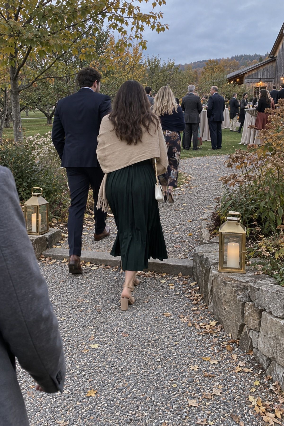 Battery lanterns mark a turn in the gravel route from ceremony to cocktail hour.