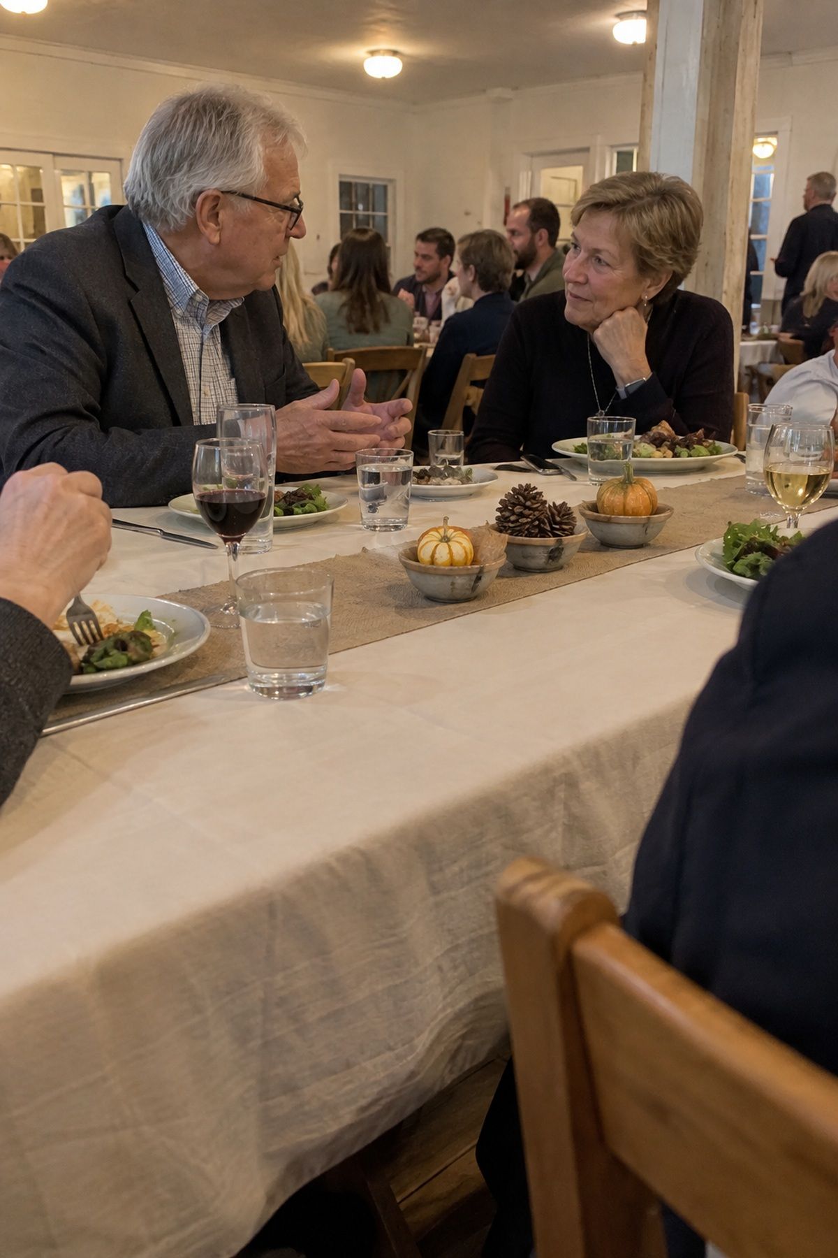 Low gourd and pinecone centerpieces keep conversation and dinner service unobstructed.