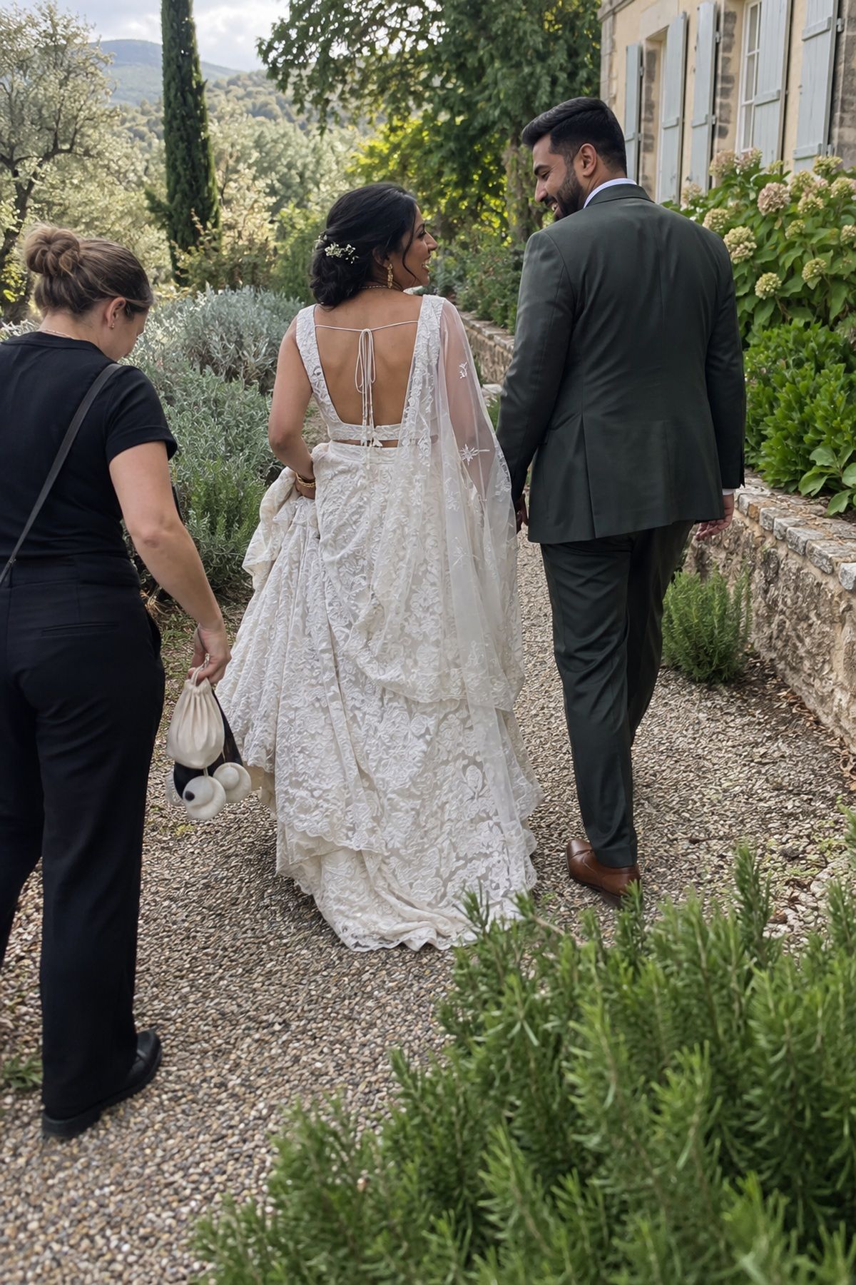 A couple walks along a garden path for relaxed September wedding photos.