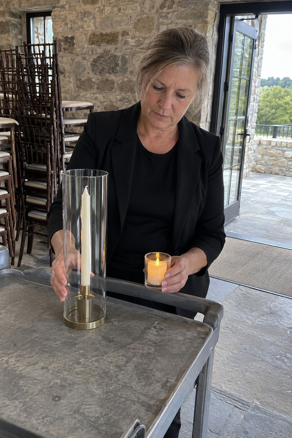 A venue manager compares a hurricane-covered taper with a battery votive.