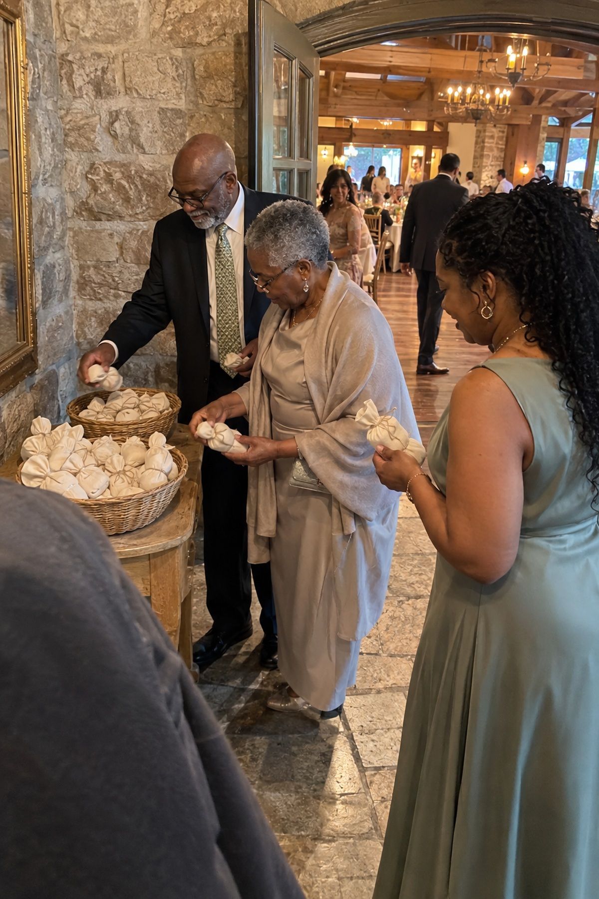 Guests choose plain cloth-wrapped wedding favors from market baskets near the exit.