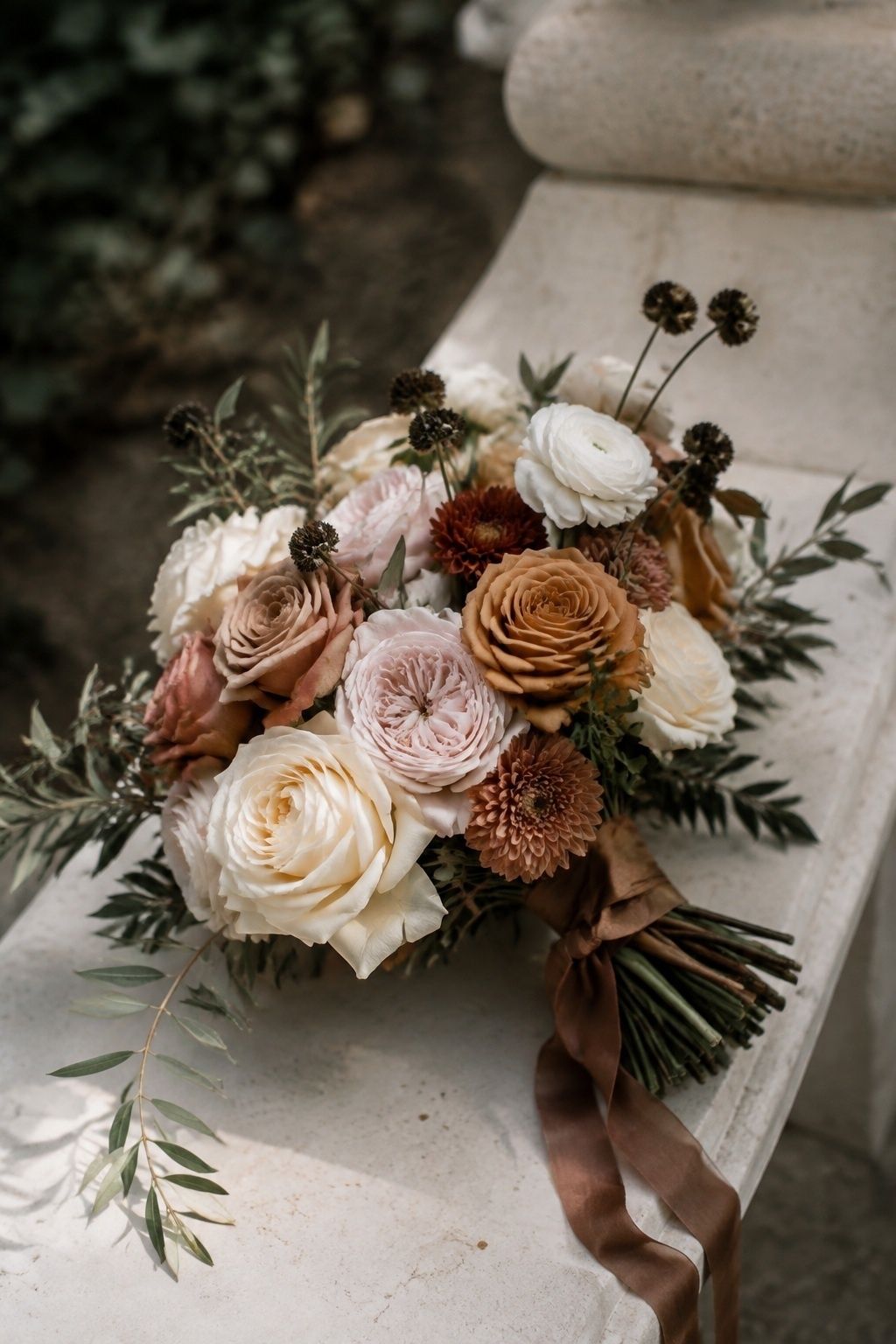 Cream and caramel bridal flowers with blush roses and olive greenery.