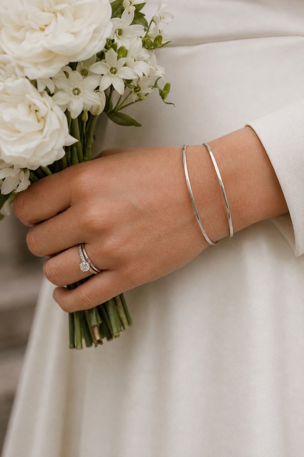 Silver bangles framing the engagement ring